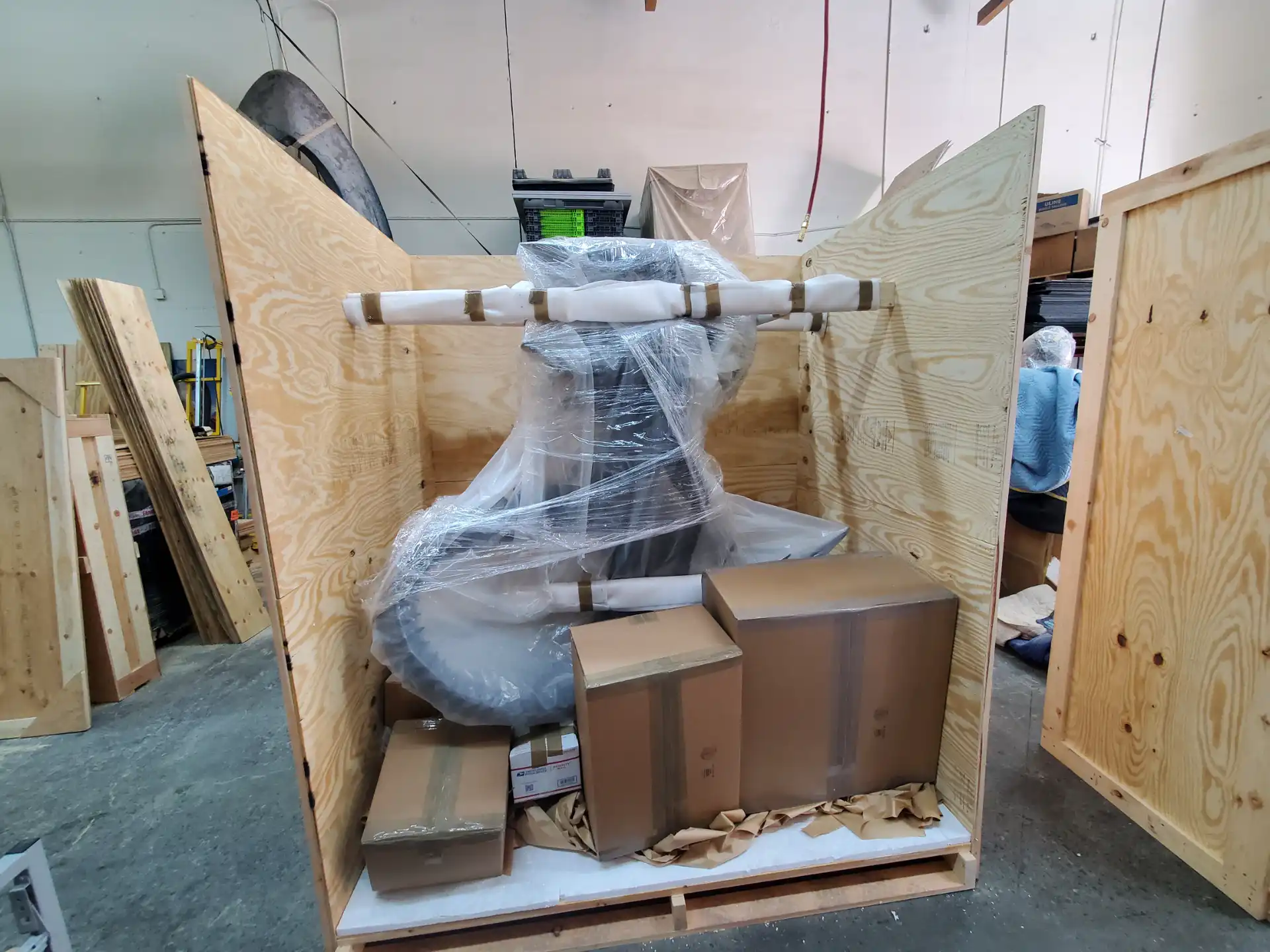 A large sculpture shrink-wrapped and blocked inside a custom-built crate