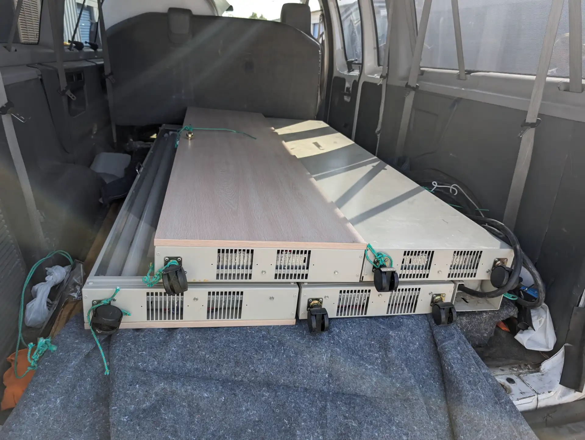 A dismantled cabinet and countertop strapped down inside a padded moving van