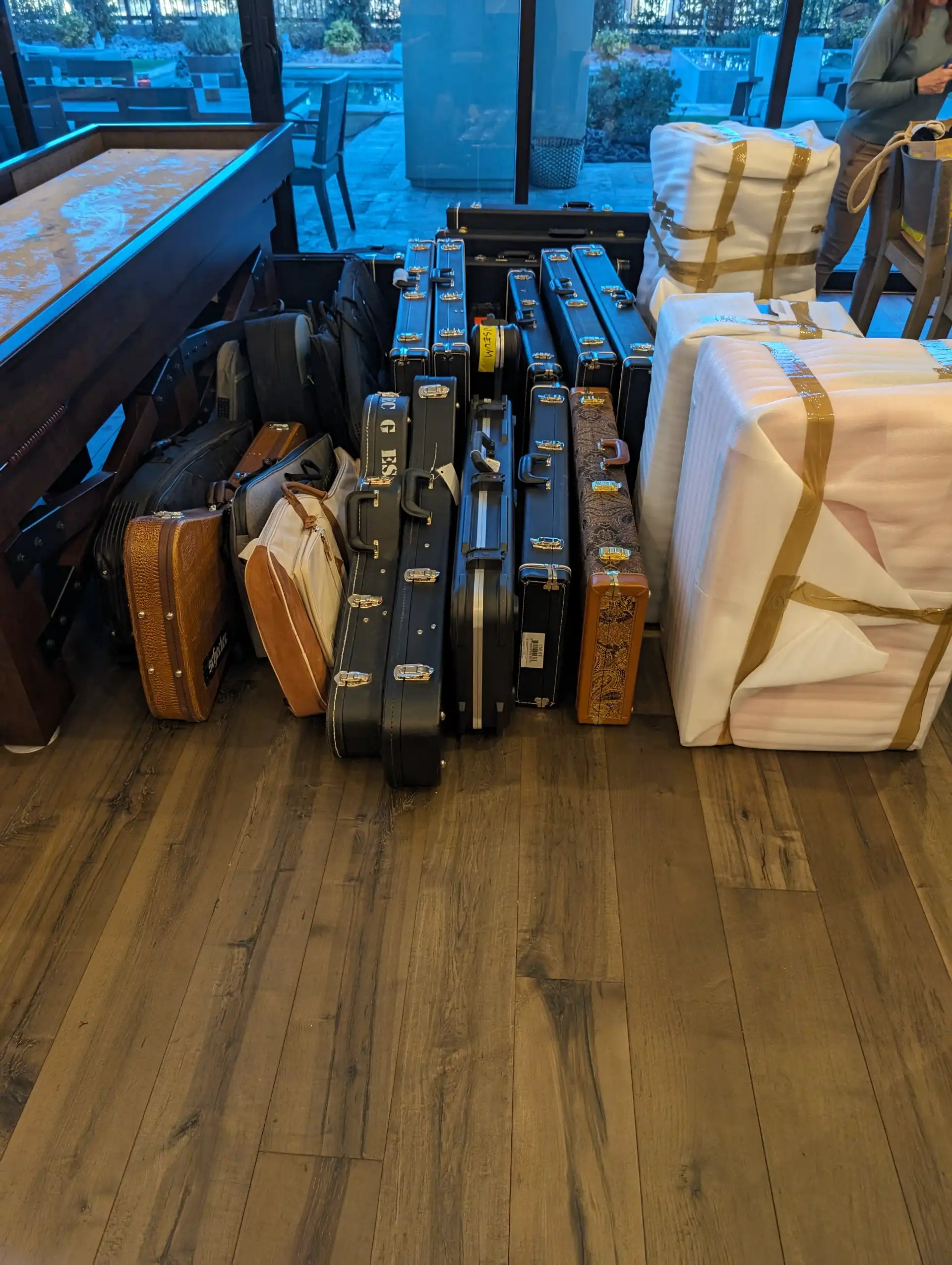 Guitar cases, luggage and blanket-wrapped furniture staged by the door ahead of a small move
