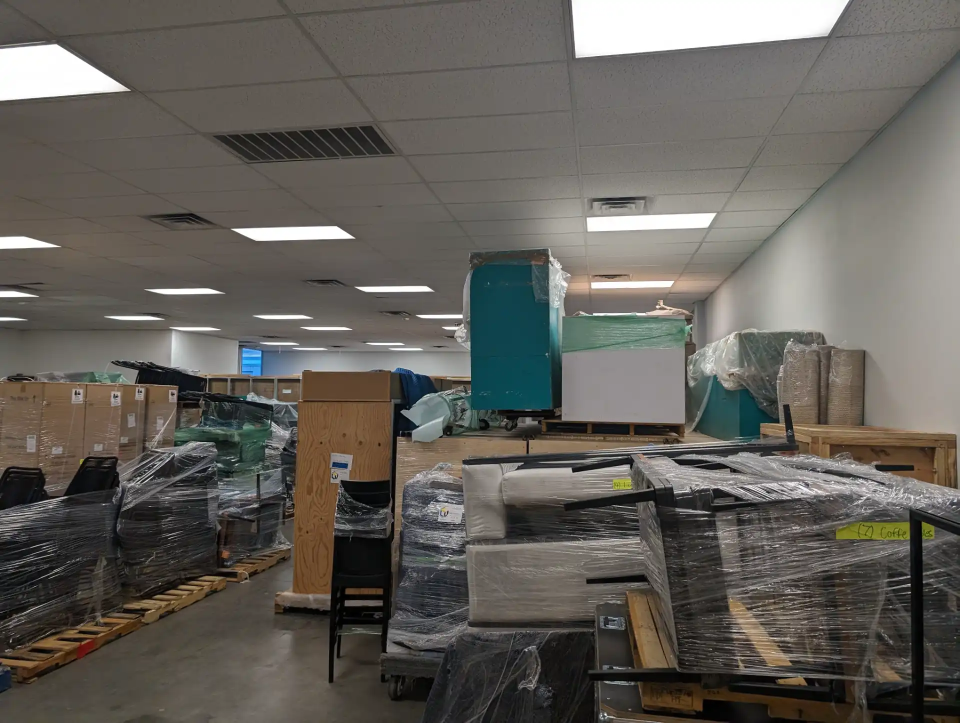 Shrink-wrapped and palletized household furniture staged inside the Las Vegas Warehouse storage floor