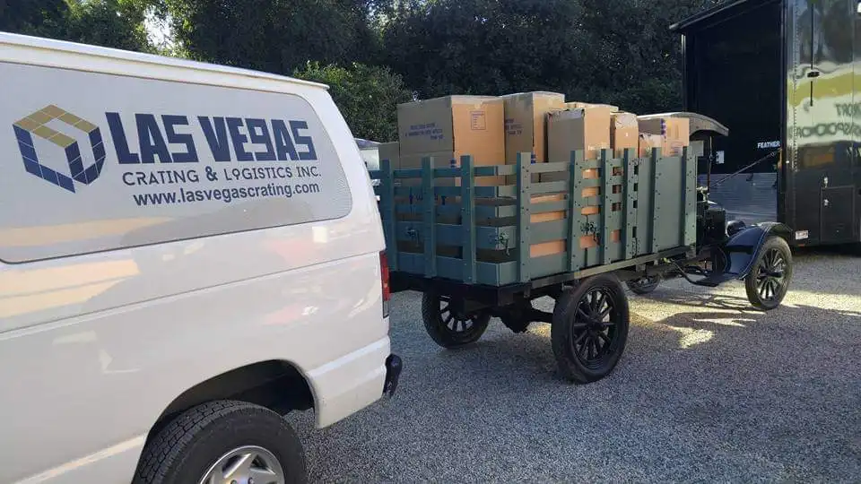 Las Vegas Crating van parked beside an antique wagon loaded with packed boxes for a local pickup